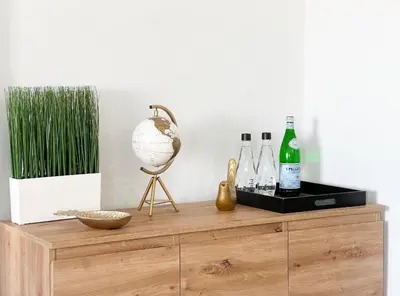 a wooden dresser with bottles and a globe on it at Sea View Apartment Albufeira in Albufeira