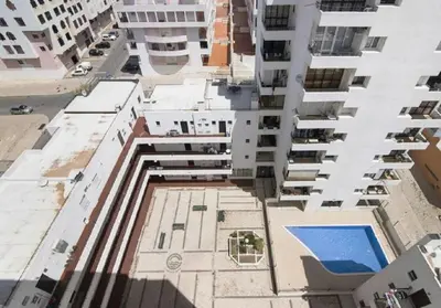 a white bedroom with a bed and a window at Algarve Paraíso Casa Solimô in Bicas