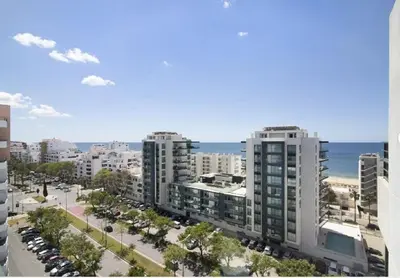 a table on a balcony with a view of the ocean at Algarve Paraíso Casa Solimô in Bicas
