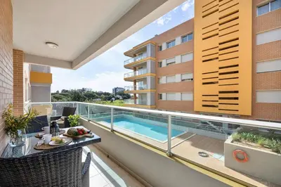 a balcony with a swimming pool on a building at Pool with Beach 10' Away - Comfort and Tranquility in Quarteira
