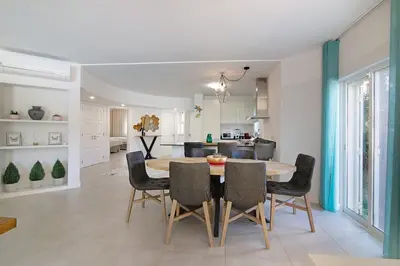 a kitchen and dining room with a table and chairs at Beautiful 2 Bedroom Self Catering Apartment with Private Pool and Garden in the Encosta do Lago Resort in Quinta do Lago in Quinta do Lago