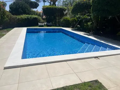 a swimming pool in a yard next to a patio at Beautiful 2 Bedroom Self Catering Apartment with Private Pool and Garden in the Encosta do Lago Resort in Quinta do Lago in Quinta do Lago
