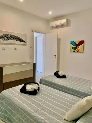 a bedroom with two beds and a window at Vila orada lola in Albufeira