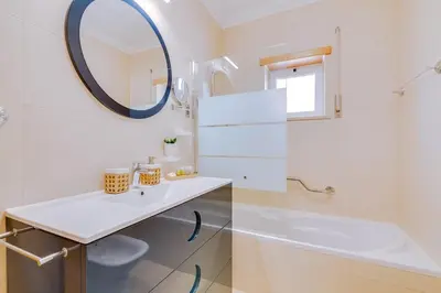 a white bathroom with a sink and a mirror at Falesia beach Pool quiet side by Enjoyyourstay in Albufeira