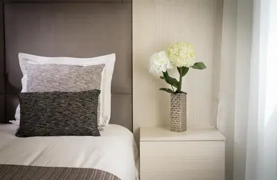 a vase with flowers on a night stand next to a bed at D_Loft Downtown in Albufeira