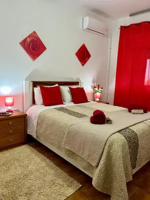 a bedroom with a large bed with red pillows at OldTownPool Albufeira in Albufeira