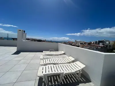 a row of white lounge chairs on a roof at OldTownPool Albufeira in Albufeira