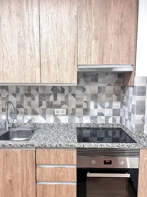 a kitchen with wooden cabinets and a sink at StayBaixa Faro in Faro