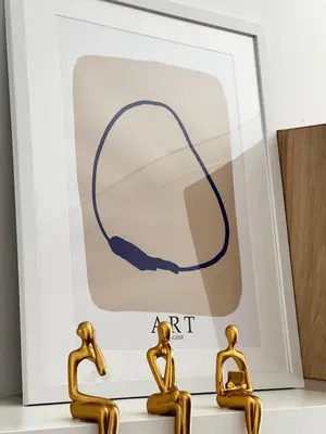 two gold statues in front of a framed picture of a circle at StayBaixa Faro in Faro