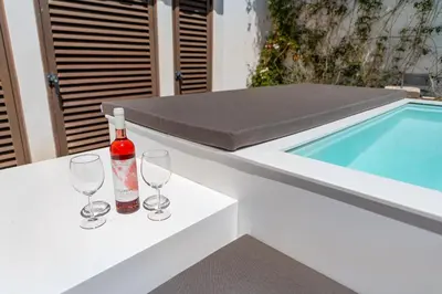 a bottle of wine and glasses on a table next to a swimming pool at Villa Ancora - Nex to the Beach - Parking - Swimming Pool - BY BEDZY in Albufeira