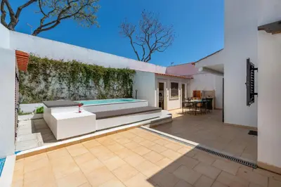 an outdoor patio with a bench and a swimming pool at Villa Ancora - Nex to the Beach - Parking - Swimming Pool - BY BEDZY in Albufeira