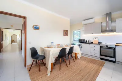a kitchen with a table and chairs in a room at Villa 4 Quartos, Piscina, BBQ Snooker, Prestige For Home in Quarteira