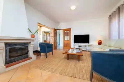 a living room with a couch and a fireplace at Villa 4 Quartos, Piscina, BBQ Snooker, Prestige For Home in Quarteira