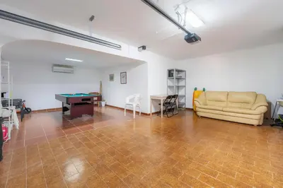 a living room with a couch and a table at Villa 4 Quartos, Piscina, BBQ Snooker, Prestige For Home in Quarteira