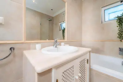 a bathroom with a sink and a mirror and a tub at Villa 4 Quartos, Piscina, BBQ Snooker, Prestige For Home in Quarteira
