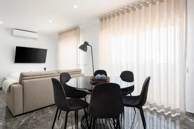 a living room with a couch and a table and chairs at Espadarte - Sea view by HD in Quarteira