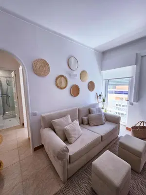 a living room with a couch and two mirrors on the wall at Faro Heart House in Faro