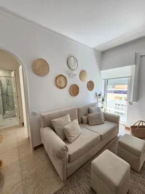 a living room with a couch and two mirrors on the wall at Faro Heart House in Faro