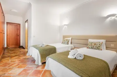 a room with two beds with towels on them at Villa Las Rosas in Albufeira