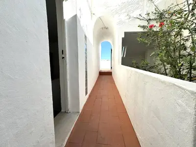 a hallway of a white building with a pathway at Villa Terraza - Center Hideaway in Albufeira
