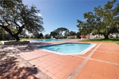 a swimming pool in a yard with trees at Albufeira Oura Apartment in Albufeira