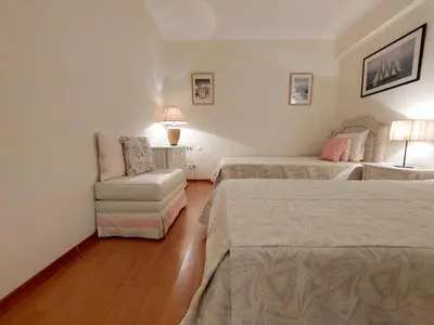 a hotel room with two beds and a chair at Marina Mar Sunset by SAPvillas in Vilamoura