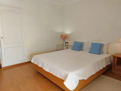 a bedroom with a large white bed with blue pillows at Marina Mar Sunset by SAPvillas in Vilamoura