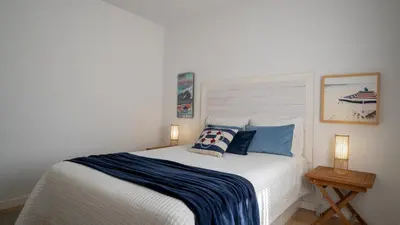 a bedroom with a large white bed with blue pillows at Luxury Beach House Apartment - Golf & Tennis Court & Pool View in Albufeira