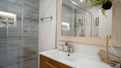 a bathroom with a sink and a glass shower at Luxury Beach House Apartment - Golf & Tennis Court & Pool View in Albufeira