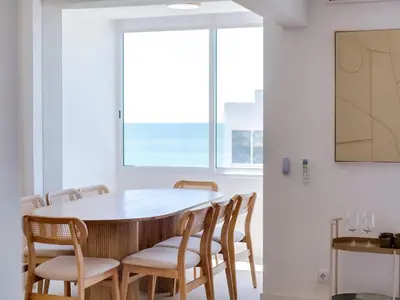 a dining room with a table and chairs and a window at Art and Sea 2 bedroom apartment in Quarteira