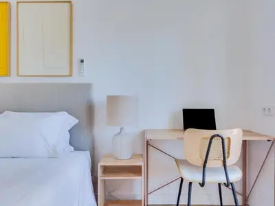 a bedroom with a desk with a chair and a bed at Art and Sea 2 bedroom apartment in Quarteira