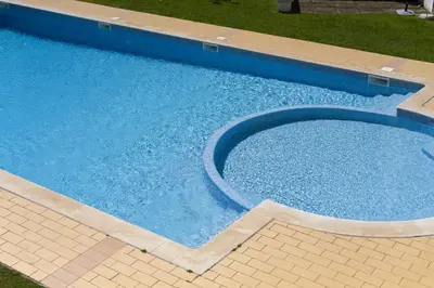 an empty swimming pool with blue water in a yard at Fonte Moura - With pool by HD in Vilamoura
