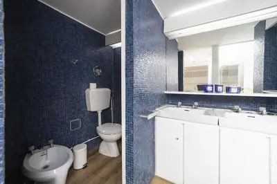 a blue tiled bathroom with a toilet and a sink at Casa da Colina in Albufeira