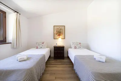 two twin beds in a room with white walls at Casa da Colina in Albufeira