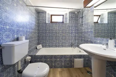 a bathroom with a tub and a toilet and a sink at Casa da Colina in Albufeira
