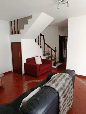 a living room with a couch and a red chair at Villa Vacations Marie in Albufeira