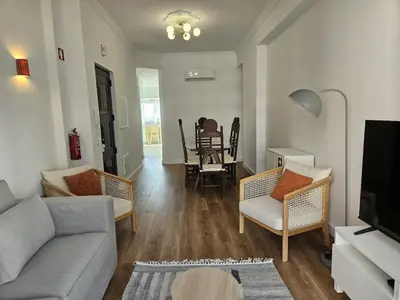 a living room with a couch and chairs and a table at Apartamento moderno com vista para o mar em Faro in Faro
