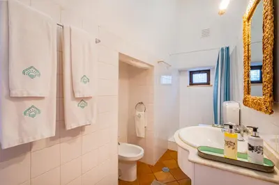 a bathroom with a sink and a toilet and towels at Quinta da Bisa - Casa das Pedrinhas in Algoz