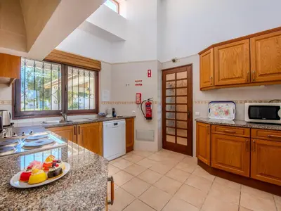 a kitchen with wooden cabinets and a counter top at Villa Rosa by Interhome in Sesmarias