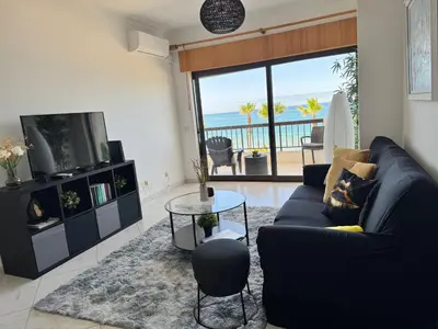 a living room with a blue couch and a television at Adrimar - Beachfront Sea View 2BR Apartment in a prime location in Quarteira