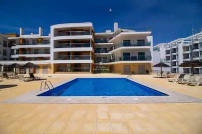 a large apartment building with a pool in front of it at Apartamento Varandas do Mar in Albufeira