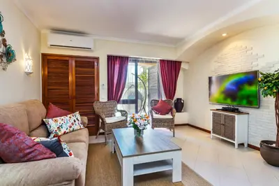 a living room with a couch and a tv at Clementina Apartment in Albufeira