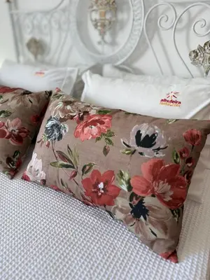 a pillow on a bed with flowers on it at Jardim Santa Eulália By Albufeira Rental in Albufeira