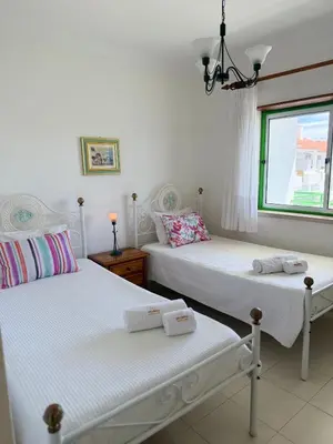 two twin beds in a room with a window at Jardim Santa Eulália By Albufeira Rental in Albufeira