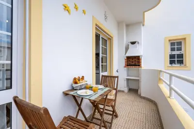 a small balcony with a table and chairs at Sunny Flat w/ Balcony near the Sea by HostWise in Albufeira