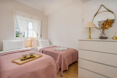 a bedroom with two beds with pink sheets and a tray of fruit at Sunny Flat w/ Balcony near the Sea by HostWise in Albufeira