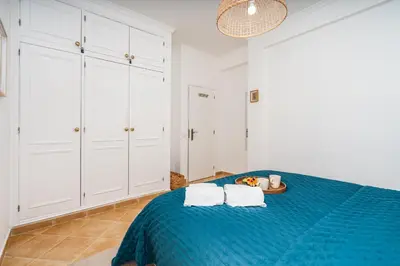 a bedroom with a blue bed with white cabinets at Sunny Flat w/ Balcony near the Sea by HostWise in Albufeira