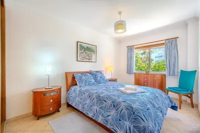 a bedroom with a blue bed and a blue chair at Apartmento Estrela de Albufeira Old Town Beach in Albufeira