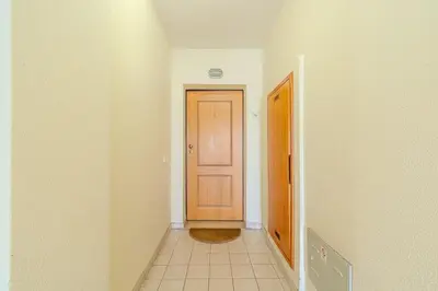 a hallway with a wooden door and a tile floor at Apartmento Estrela de Albufeira Old Town Beach in Albufeira