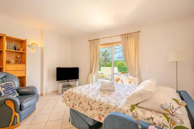 a bedroom with a bed and a couch and a television at Apartmento Estrela de Albufeira Old Town Beach in Albufeira
